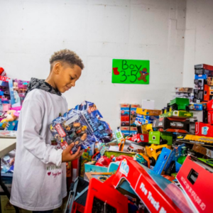 Volunteer Tristan Powell, 8, looks at a toy at the Frederick County Toys for Tots warehouse on Thomas Johnson Drive.